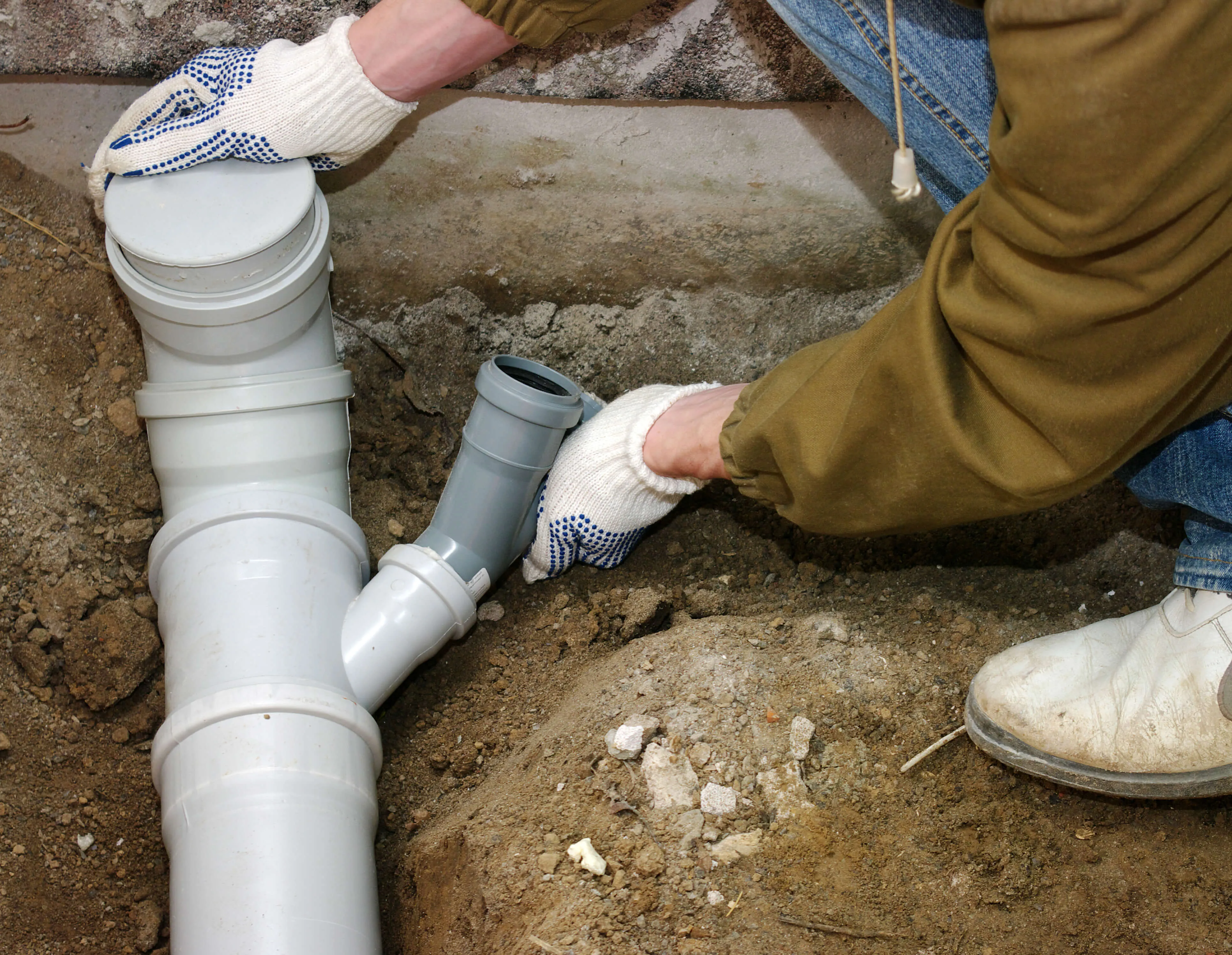 692de50ee94cecc3215272b5_bigstock Plumber assembling pvc sewage 48326390
